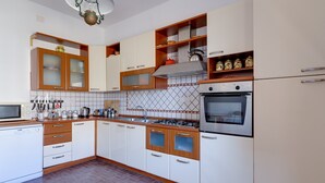 A modern kitchen with white and wooden cabinets, a built-in oven, and a tiled backsplash. - Villa Timbora on the Beach with Ocean View, Terrace (Cabras)