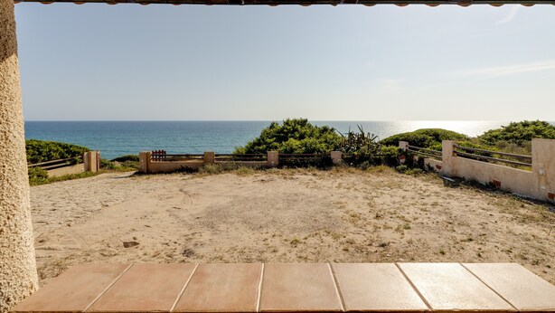 A beach view from a covered area with a sandy foreground and a clear blue sky. - Villa Timbora on the Beach with Ocean View, Terrace (Cabras)