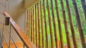 Eine Treppe mit Bambusgeländern und Blick auf die grüne Umgebung.