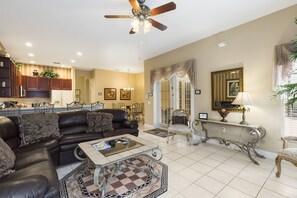 A spacious living area with a leather sofa, a coffee table, and a dining area in the background. - Closest to Disney by VillaDirect (Kissimmee)