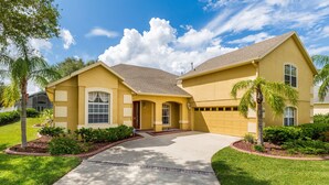 A two-story house with a front yard, driveway, and a garage. - Closest to Disney by VillaDirect (Kissimmee)