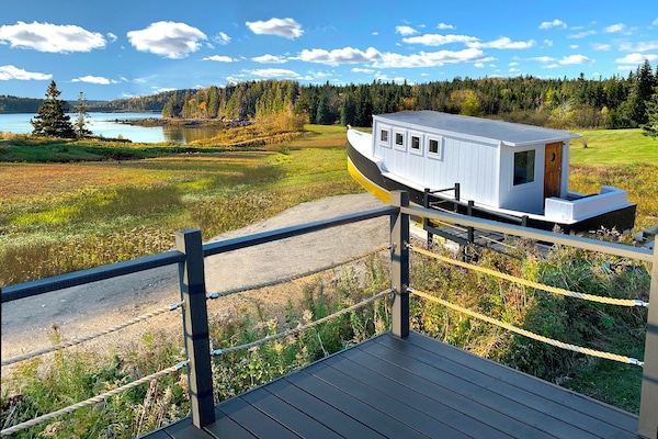 The Dock House and lobster boat lounge overlook Holmes Bay and a nature reserve.