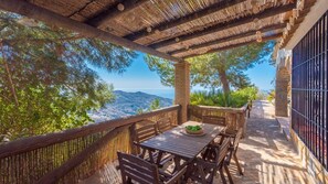 Una terraza de madera con una mesa y sillas, con vistas a un paisaje pintoresco.