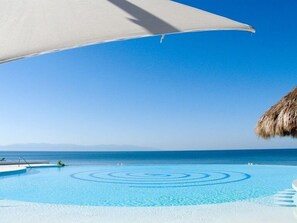 Alberca al aire libre, sombrillas en la alberca y camastros 