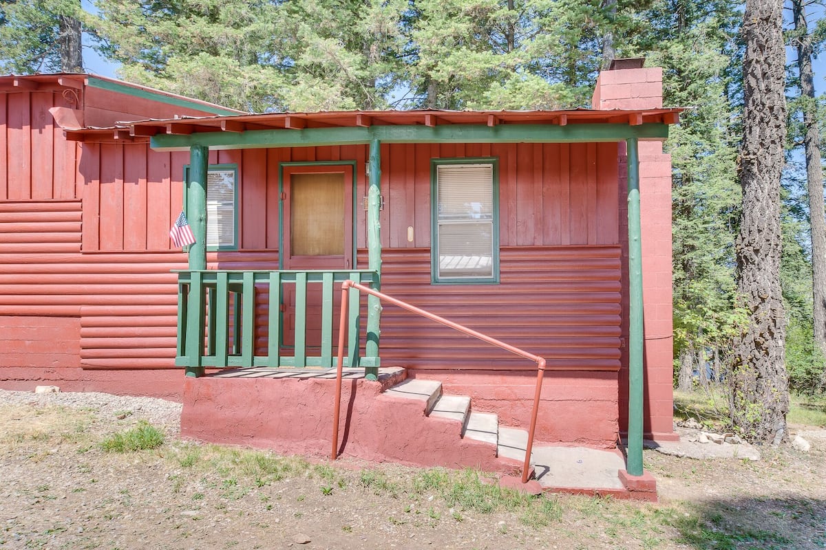 Eine rustikale Holzhütte mit Veranda, Tür und Fenster.