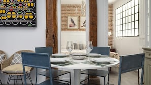 A dining area with a round table set for four, surrounded by blue chairs. - Fantastic apartment in Barrio de las Letras (Madrid)
