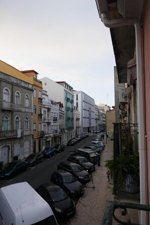 A street view with parked cars and buildings.