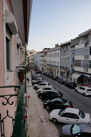 A street view with parked cars and buildings.