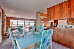 Enjoy meals in this cozy dining area with a long table for four, surrounded by rustic charm and a beautiful view.