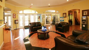 A lobby with leather sofas, a coffee table, and an ATM. - The Floridian by VillaDirect (Kissimmee)