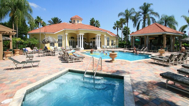 A pool area with multiple pools, lounge chairs, and umbrellas. - The Floridian by VillaDirect (Kissimmee)