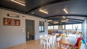 A modern interior with a dining area, a sofa set, and a large window offering a view. - Sist 34 Suit Hotel (Serdivan)