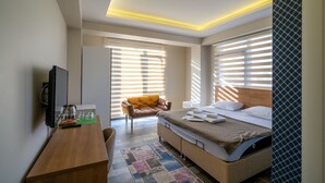 A modern hotel room with a bed, a desk, a chair, and a TV. - Sist 34 Suit Hotel (Serdivan)