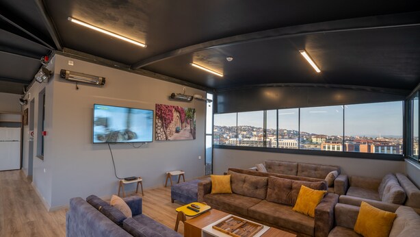 A modern living room with a large window, sofas, a coffee table, and a flat-screen TV. - Sist 34 Suit Hotel (Serdivan)
