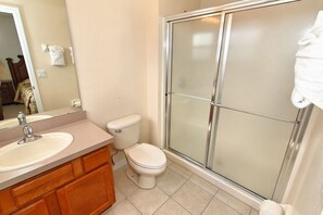 A bathroom with a sink, toilet, and glass shower enclosure. - Mickeys Lodge by VillaDirect (Kissimmee)