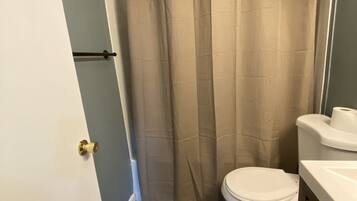 Ensemble baignoire-douche, savon, papier de toilette