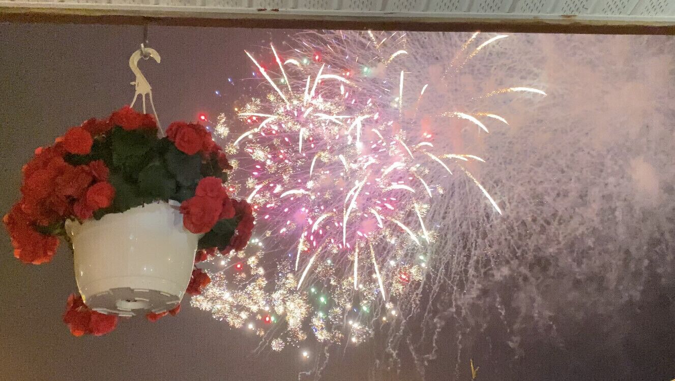 Une pièce dotée d’une grande fenêtre donnant sur un spectacle de feux d’artifice.