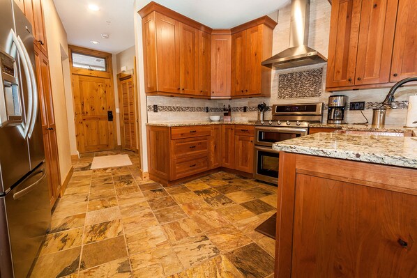 Enjoy cooking in this well-equipped kitchen with a large island, stainless steel appliances, and a spacious sink.