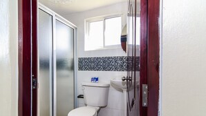 Ein kleines Badezimmer mit Toilette, Waschbecken und Duschbereich.