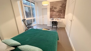 Een slaapkamer met een bed, een bureau en een stoel.