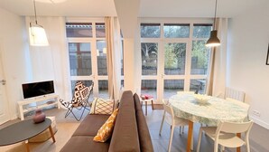 Een moderne woonkamer met een bank, een eettafel en een televisie.