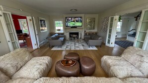 A spacious living room with a fireplace, leather sofas, and a television. - Luxury Home with Amazing Water Views - Perfect for an intimate family gathering (Mamaroneck)