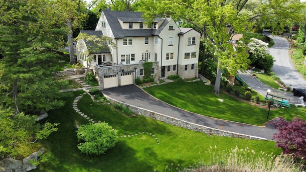 A large, two-story house with a stone driveway and a well-maintained lawn. - Luxury Home with Amazing Water Views - Perfect for an intimate family gathering (Mamaroneck)