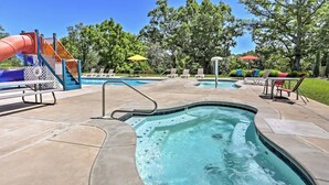 A swimming pool with a hot tub, surrounded by lounge chairs and a playground. - Close to SCD, Both Indoor & Outdoot pools, Possum Tracks Lodge  4BR/4BA Lodge (Branson West)
