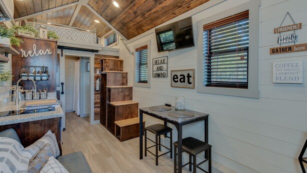 A cozy, rustic kitchen with wooden accents, a built-in seating area, and motivational wall art. - Newly Built Tiny House Near College Station and Round Top Area (Caldwell)