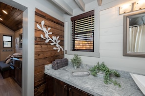 Enjoy cooking in this stylish kitchen with a granite countertop, sink, and decorative metal tray.