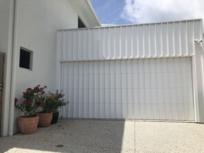 Two potted plants adorn the exterior of this building, adding a touch of greenery to the concrete surroundings.