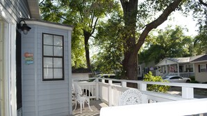 Un edificio blanco con un porche, una ventana pequeña y un letrero que dice 'Life is better in my town'.