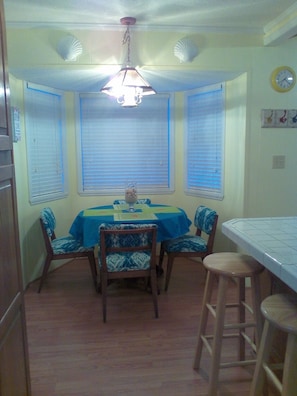 Cozy dining area with a round table and four chairs, complete with a pendant light fixture.