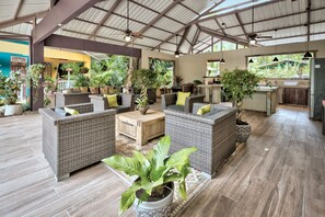 Un espace intérieur spacieux, aménagé avec des meubles en osier, des plantes en pot et un coin cuisine.