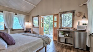 Un dormitorio con cama, una kitchenette pequeña y vistas al exterior.