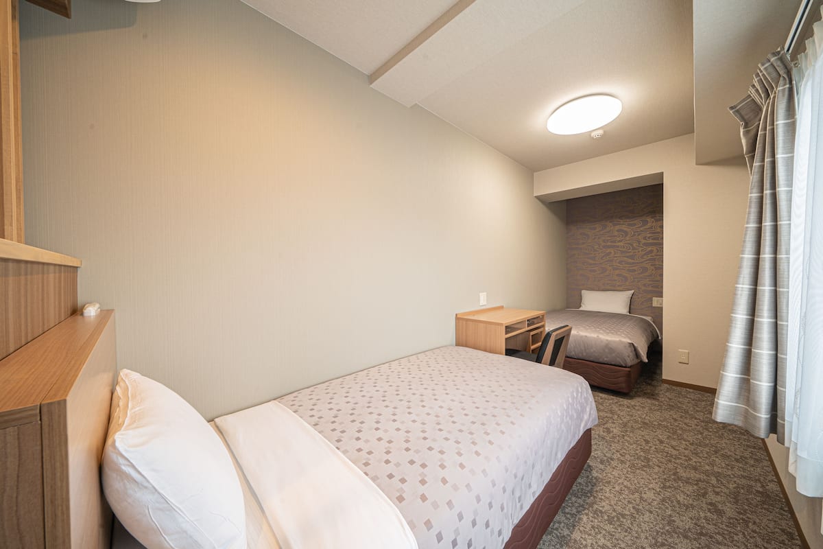 Una habitación de hotel con una cama, un escritorio y un pequeño rincón de descanso.