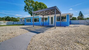 A modern building with a blue exterior, a covered outdoor area, and a gravel ground. - Boat Dock & Kayaks: Canalfront Home in Homosassa (Homosassa)