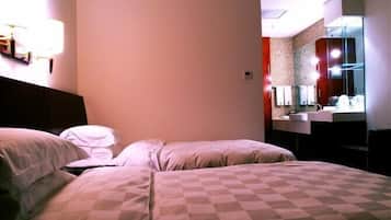 Habitación de hotel con dos camas, un espejo grande y un baño con lavamanos y espejo.