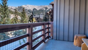 A balcony with a view of mountains, wooden railings, and a wooden bench. - Beautiful Views, Beautiful Condo , wifi, underground park, 1 minute to lifts (Copper Mountain)