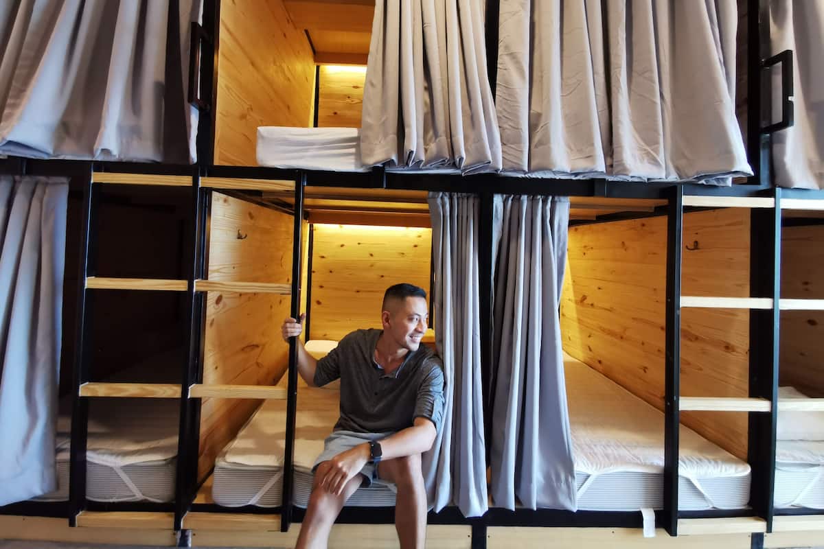 Habitación con literas, paredes de madera y cortinas.