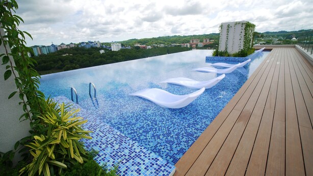 A rooftop infinity pool with a wooden deck and a cityscape view. - 118 Residence (Bandar Seri Begawan)
