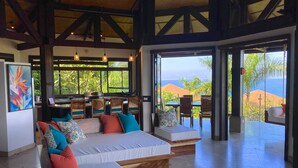 Un dormitorio espacioso con una cama grande, varios rincones de descanso y vistas al océano.