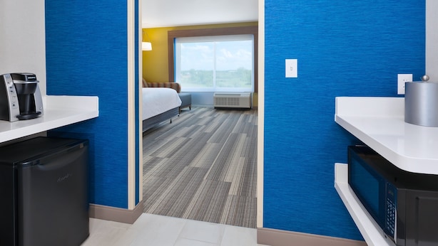 Habitación de hotel con cama, ventana, escritorio y microondas.