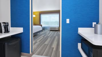 Habitación de hotel con cama, ventana, escritorio y cafetera, además de un microondas.