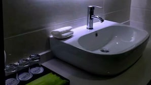 A bathroom with a white sink, a mirror, and a towel rack. - Yabuli Skier Hotel (Harbin)