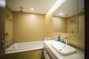 Bathroom features a large bathtub, separate sink area, and showerhead.