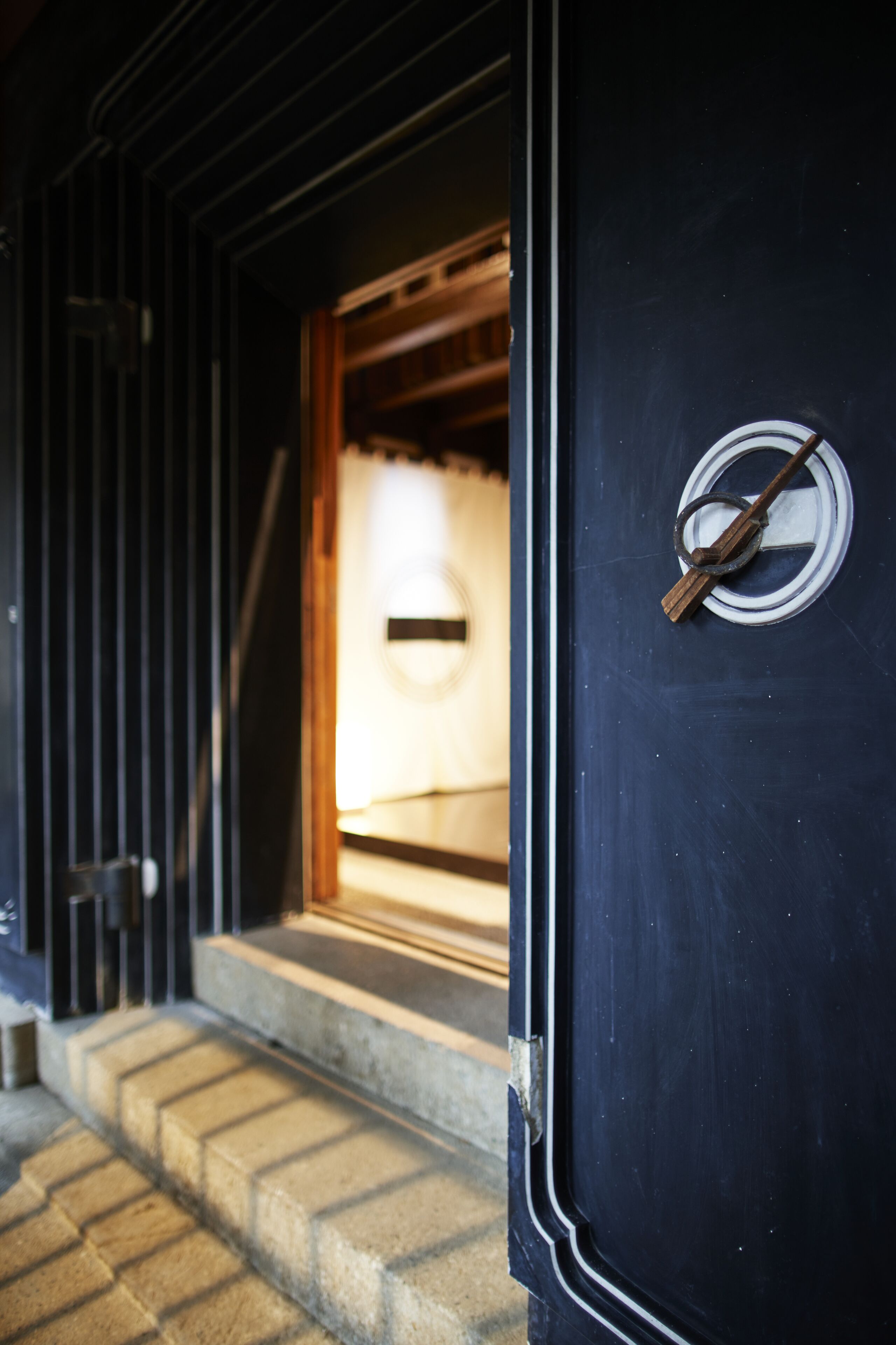 A dark wooden door with a circular window and a metal handle.