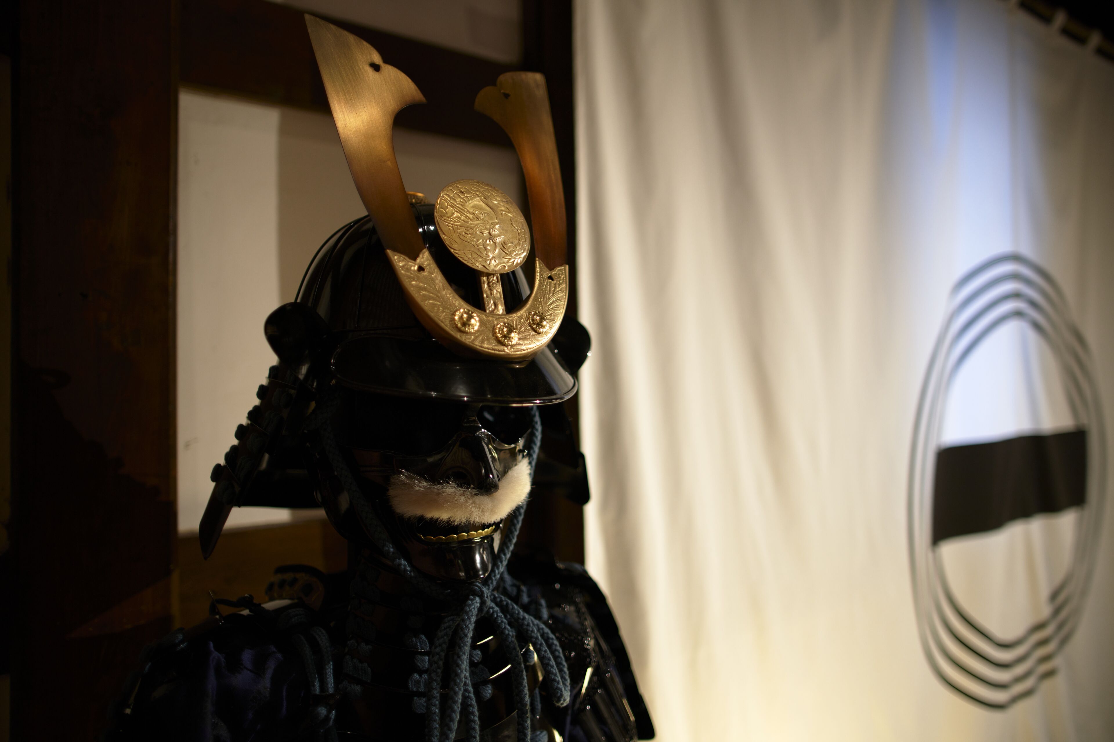 Presentación de un casco samurai con un emblema decorativo.