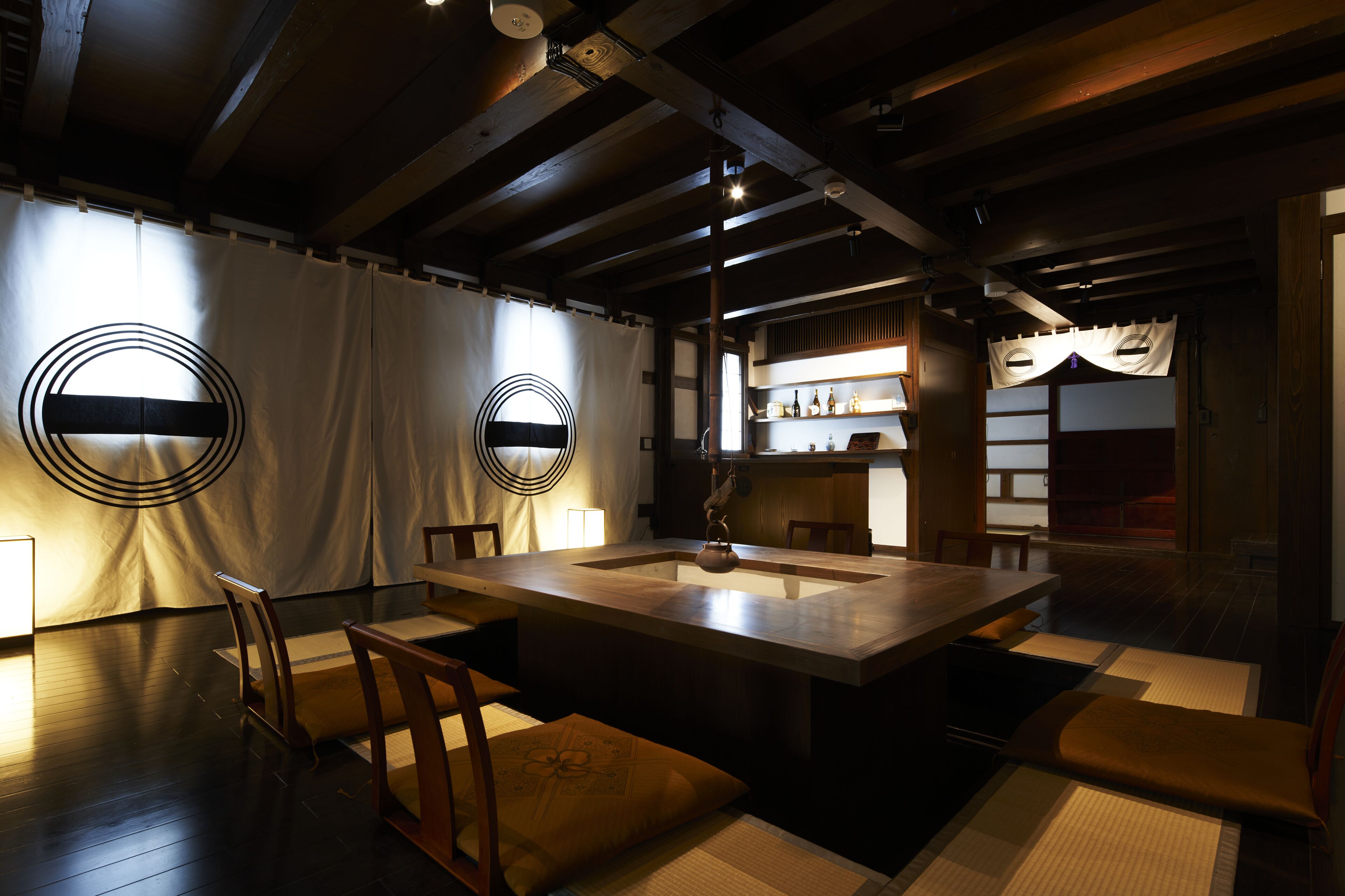 A traditional Japanese-style room with tatami mats, a low wooden table, and a tea set.