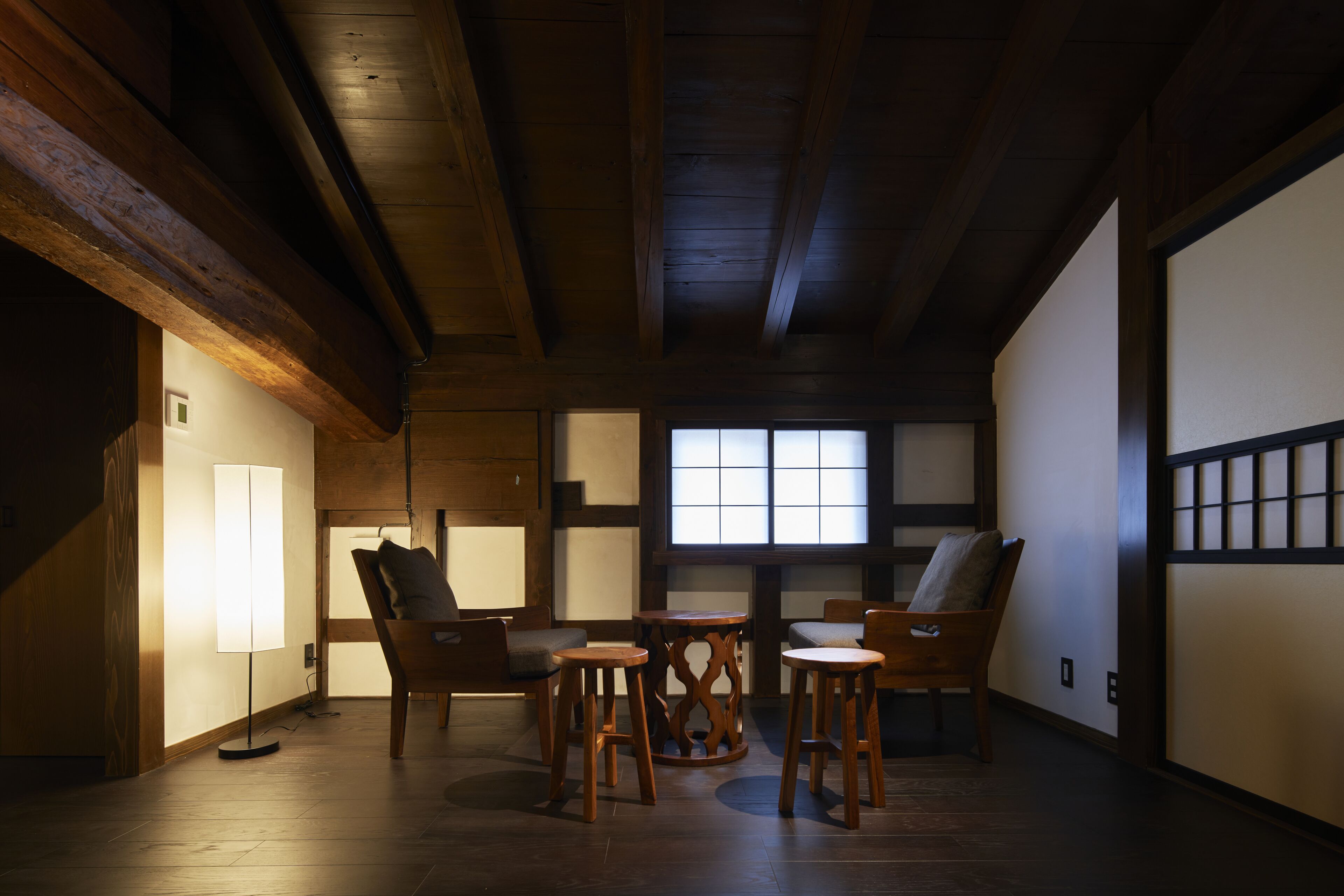 A traditional Japanese-style room with tatami flooring, wooden furniture, and a sliding door.